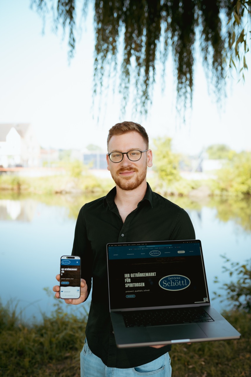 Ferdi zeigt eine fertige Website auf dem Laptop